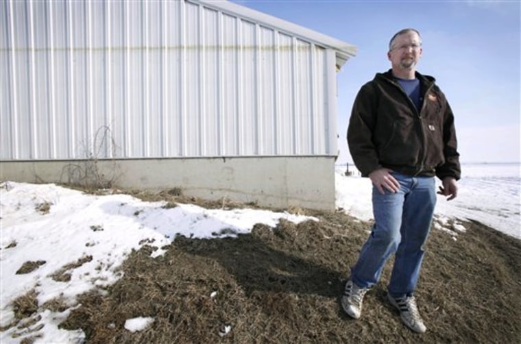 Doug Boyer of Oakville, Iowa, stands near a hog confinement building on his farm that shows a high water mark from the flood of 2008. He's among those critical of FEMA's new flood maps..